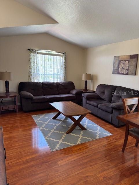 5435 Bryce Canyon Dr, Kissimmee, FL 34758 - living room with lofted ceiling and wood finished floors