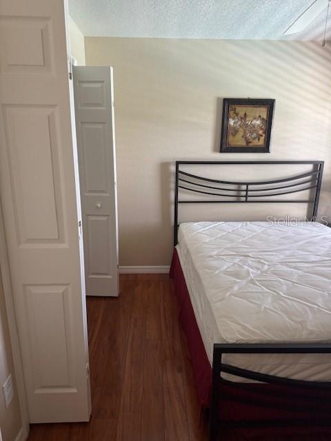 5435 Bryce Canyon Dr, Kissimmee, FL 34758 - bedroom with wood finished floors and a textured ceiling