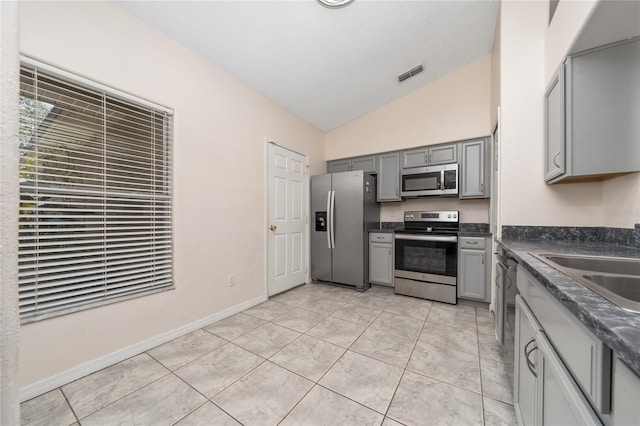 11649 Crescent Pines Blvd, Clermont, FL 34711 - kitchen featuring stainless steel appliances, gray cabinetry, vaulted ceiling, dark countertops, and light tile patterned floors