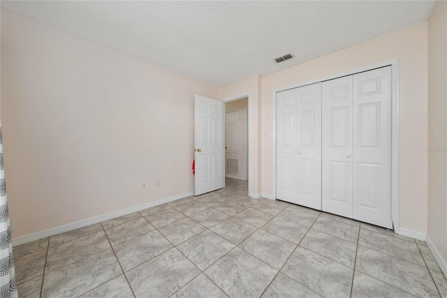 11649 Crescent Pines Blvd, Clermont, FL 34711 - unfurnished bedroom featuring light tile patterned floors, a closet, and a textured ceiling