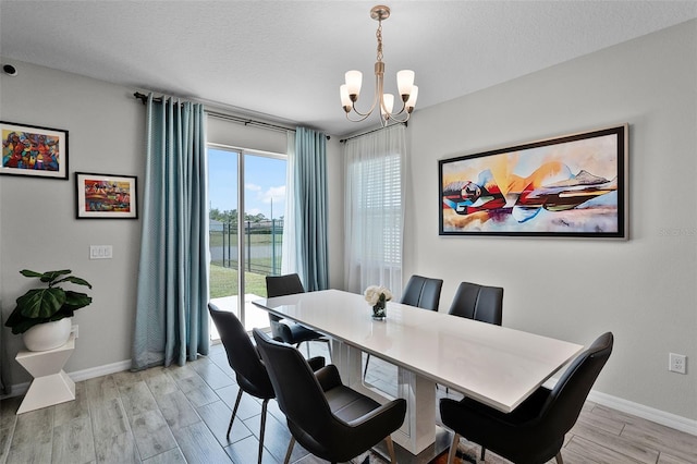 2436 Bulrush Dr, Saint Cloud, FL 34769 - dining space with a chandelier, light wood-style floors, and a water view