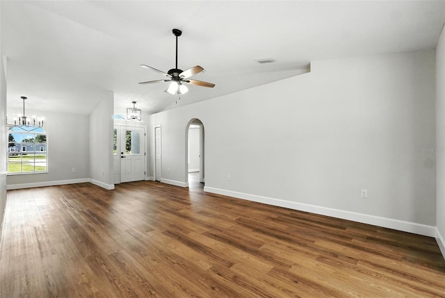 4635 Deer Run Rd, Saint Cloud, FL 34772 - unfurnished living room featuring a chandelier, ceiling fan, wood finished floors, vaulted ceiling, and arched walkways