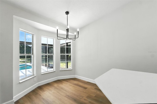 4635 Deer Run Rd, Saint Cloud, FL 34772 - unfurnished dining area featuring healthy amount of natural light, a chandelier, and wood finished floors