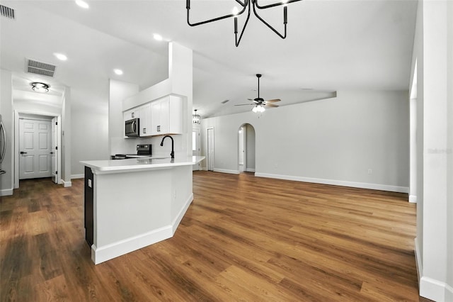 4635 Deer Run Rd, Saint Cloud, FL 34772 - kitchen featuring stainless steel appliances, light countertops, white cabinets, arched walkways, and dark wood-style floors
