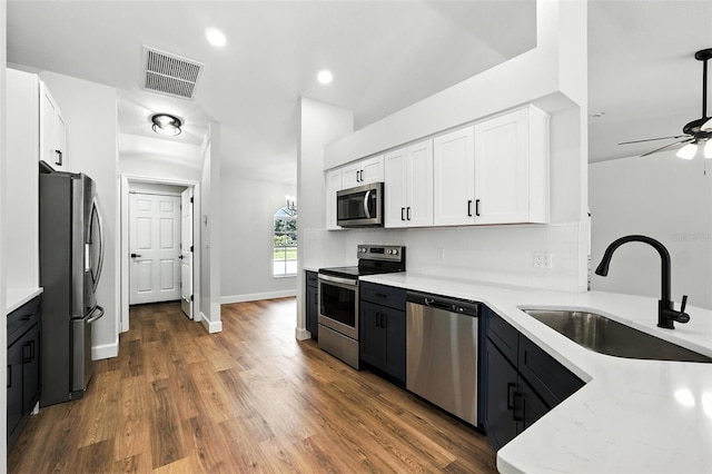 4635 Deer Run Rd, Saint Cloud, FL 34772 - kitchen with appliances with stainless steel finishes, white cabinets, a ceiling fan, wood finished floors, and recessed lighting