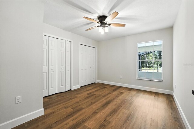 4635 Deer Run Rd, Saint Cloud, FL 34772 - unfurnished bedroom featuring two closets, dark wood-type flooring, and a ceiling fan