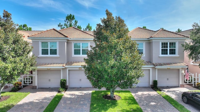 8309 Bella Vida Cir Unit 8309, Davenport, FL 33896 - mediterranean / spanish-style house featuring a tiled roof, stucco siding, and a garage