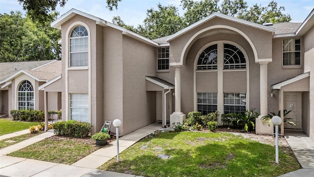 1645 Windsor Oak Ct, Kissimmee, FL 34744 - view of front of property with stucco siding, a front lawn, and a shingled roof