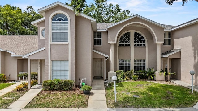 1645 Windsor Oak Ct, Kissimmee, FL 34744 - view of front of home featuring stucco siding, a front lawn, and a shingled roof