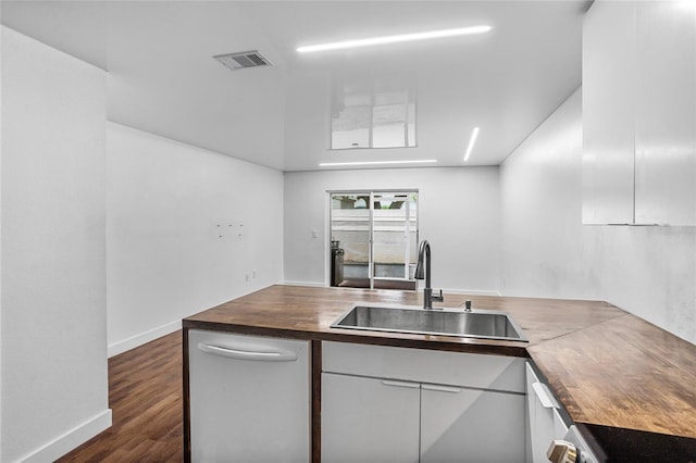 1645 Windsor Oak Ct, Kissimmee, FL 34744 - kitchen featuring butcher block counters, white dishwasher, dark wood-style floors, and a peninsula
