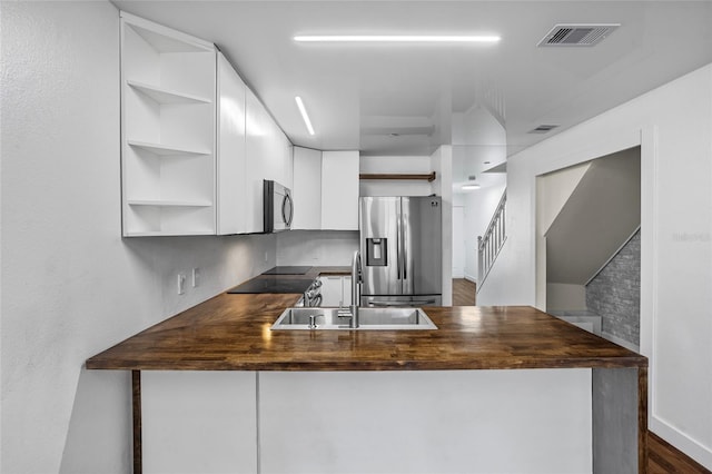 1645 Windsor Oak Ct, Kissimmee, FL 34744 - kitchen with open shelves, appliances with stainless steel finishes, white cabinets, and a peninsula