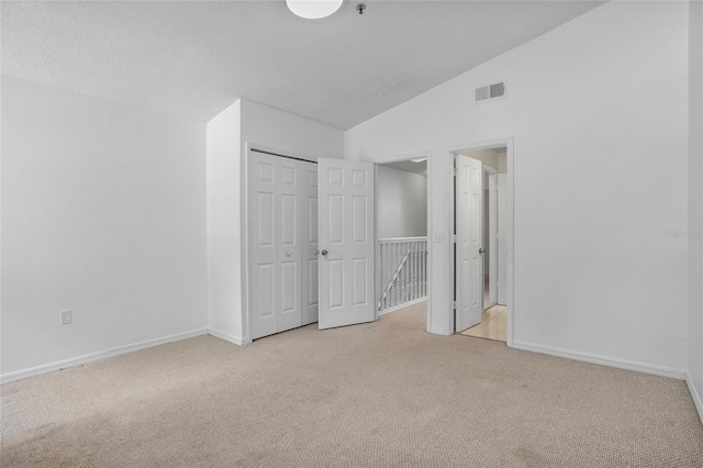 1645 Windsor Oak Ct, Kissimmee, FL 34744 - unfurnished bedroom with light carpet, lofted ceiling, and a closet