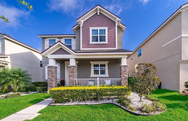 2463 Volunteer Ave, Kissimmee, FL 34744 - craftsman-style home featuring covered porch, stone siding, a front yard, and stucco siding