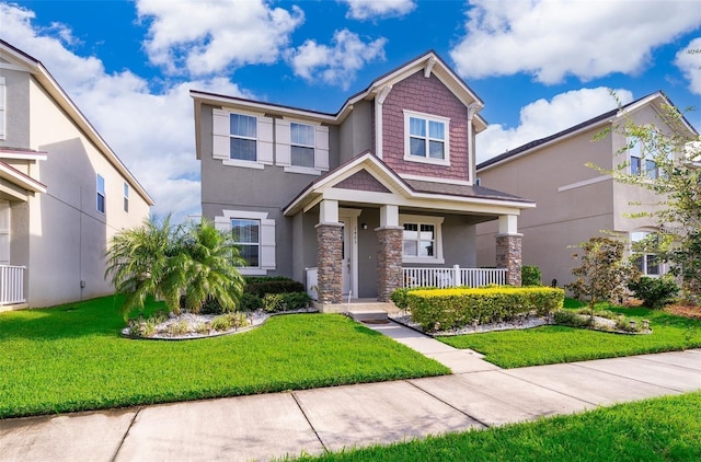 2463 Volunteer Ave, Kissimmee, FL 34744 - craftsman inspired home with a porch, stone siding, a front yard, and stucco siding
