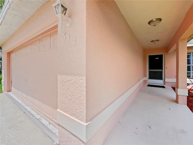 314 Clermont Dr, Kissimmee, FL 34759 - view of exterior entry featuring stucco siding and a garage