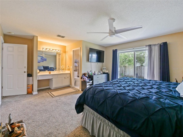 314 Clermont Dr, Kissimmee, FL 34759 - bedroom with light colored carpet, a textured ceiling, ensuite bath, a ceiling fan, and a desk