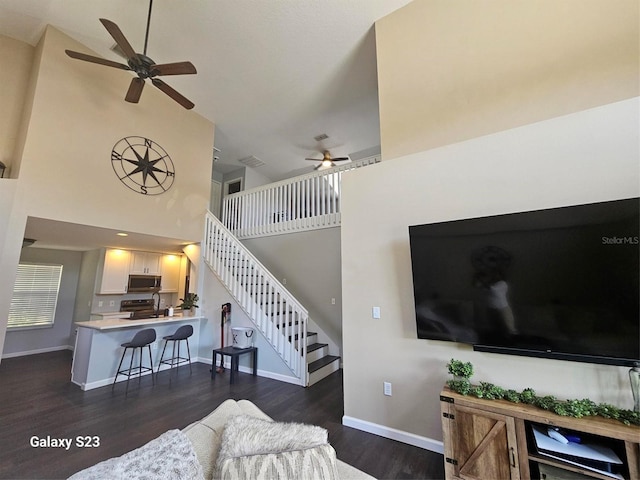 407 Darlington Loop, Davenport, FL 33896 - living area featuring a ceiling fan, high vaulted ceiling, dark wood-style flooring, and stairs