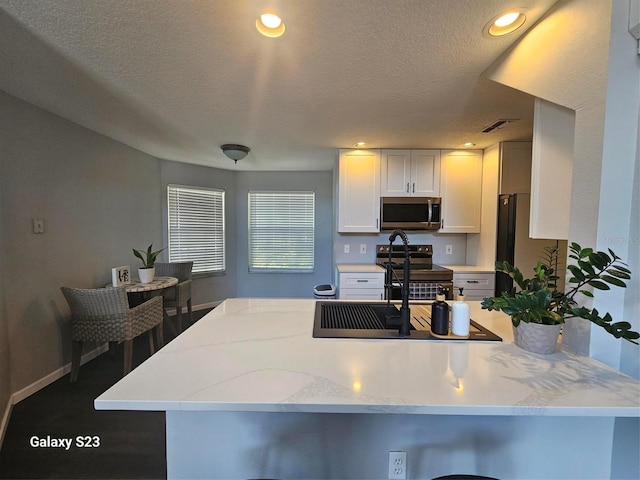407 Darlington Loop, Davenport, FL 33896 - kitchen with stainless steel microwave, electric range, light stone counters, white cabinets, and recessed lighting