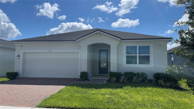 1089 Turquoise Waves Cv, Kissimmee, FL 34747 - ranch-style house featuring decorative driveway, stucco siding, a front yard, and an attached garage