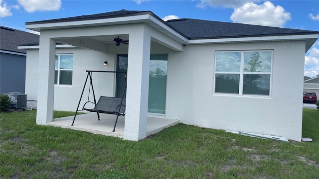1089 Turquoise Waves Cv, Kissimmee, FL 34747 - back of property with a patio area, stucco siding, a lawn, and roof with shingles