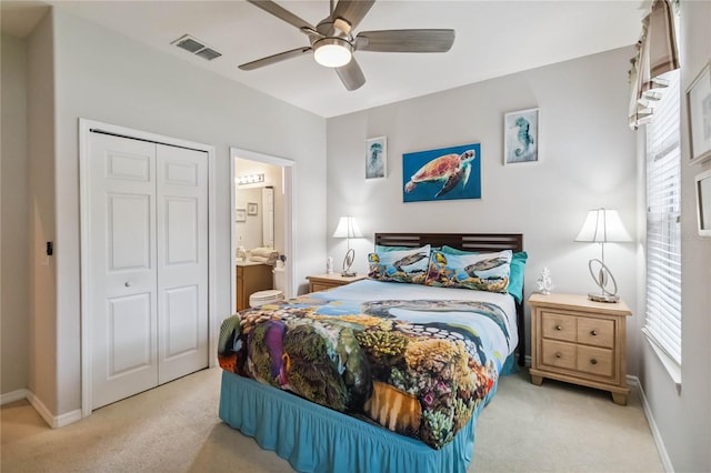 163 Tigerlily Ct, Davenport, FL 33837 - bedroom with light colored carpet, a closet, a ceiling fan, and ensuite bath