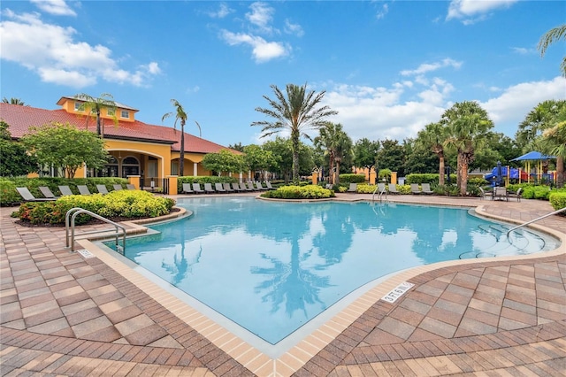 163 Tigerlily Ct, Davenport, FL 33837 - community pool featuring a patio
