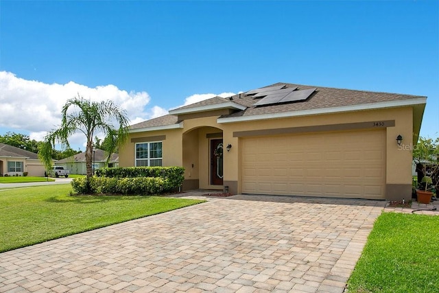 3430 Harlequin Dr, Saint Cloud, FL 34772 - view of front of property with stucco siding, roof mounted solar panels, a front lawn, decorative driveway, and a garage