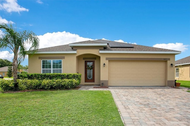 3430 Harlequin Dr, Saint Cloud, FL 34772 - view of front facade featuring stucco siding, solar panels, a front yard, a garage, and decorative driveway