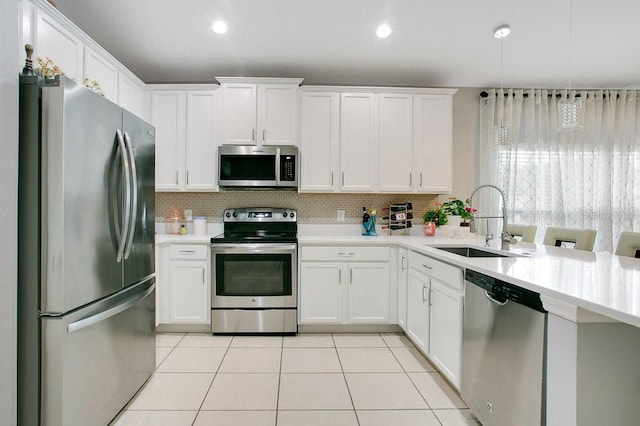 3430 Harlequin Dr, Saint Cloud, FL 34772 - kitchen featuring appliances with stainless steel finishes, light countertops, light tile patterned flooring, decorative backsplash, and white cabinets