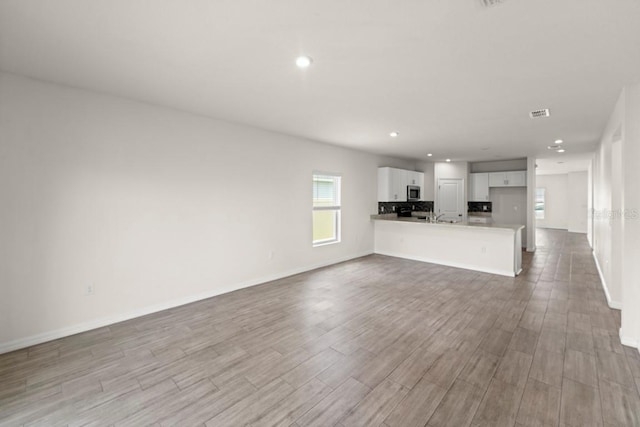 588 Meadow Bend Dr, Davenport, FL 33837 - unfurnished living room with light wood finished floors and recessed lighting