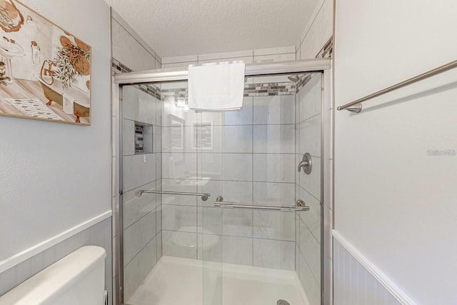 120 Bloomingdale Dr, Davenport, FL 33897 - full bath featuring a stall shower, wainscoting, and a textured ceiling