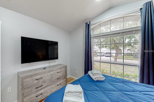 120 Bloomingdale Dr, Davenport, FL 33897 - bedroom featuring vaulted ceiling, light wood-style flooring, and a textured ceiling