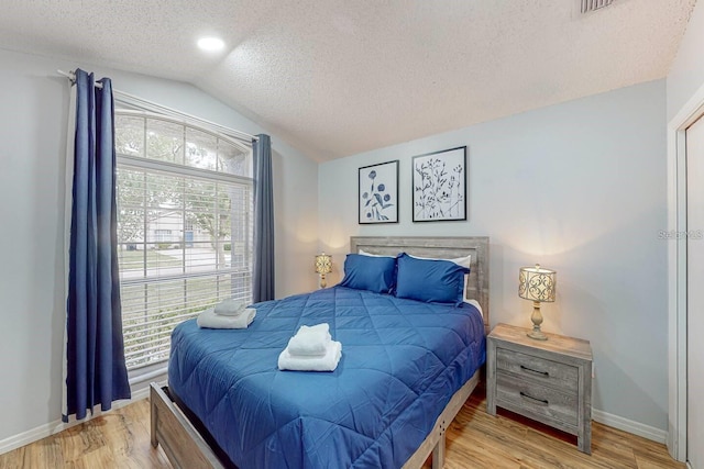 120 Bloomingdale Dr, Davenport, FL 33897 - bedroom featuring a textured ceiling, lofted ceiling, and light wood finished floors