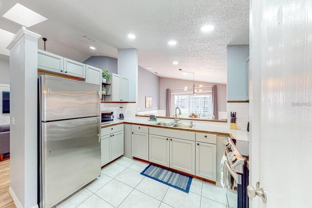 120 Bloomingdale Dr, Davenport, FL 33897 - kitchen with stainless steel appliances, vaulted ceiling, open shelves, light countertops, and a textured ceiling