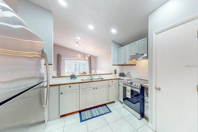 120 Bloomingdale Dr, Davenport, FL 33897 - kitchen with appliances with stainless steel finishes, under cabinet range hood, tasteful backsplash, a textured ceiling, and vaulted ceiling