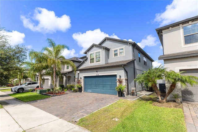 9878 Aurea Moss Ln, Orlando, FL 32832 - view of front facade with stucco siding, a garage, decorative driveway, and a front yard
