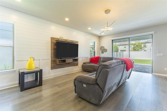9878 Aurea Moss Ln, Orlando, FL 32832 - living room with wood finished floors, recessed lighting, a textured ceiling, and a chandelier