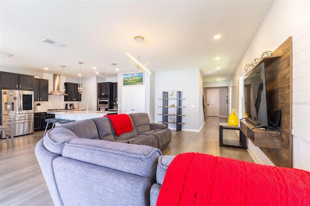 9878 Aurea Moss Ln, Orlando, FL 32832 - living room featuring light wood finished floors and recessed lighting