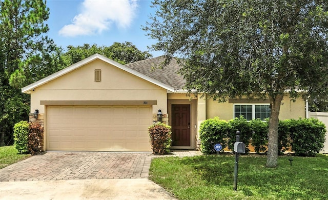 301 Sierra Way, Davenport, FL 33837 - view of front of house featuring stucco siding, decorative driveway, a shingled roof, and an attached garage