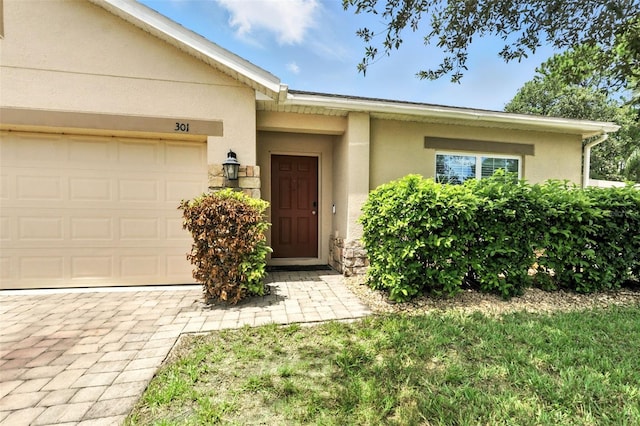 301 Sierra Way, Davenport, FL 33837 - view of exterior entry featuring stucco siding and a garage