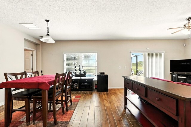 301 Sierra Way, Davenport, FL 33837 - dining room with wood finished floors, ceiling fan, and a textured ceiling