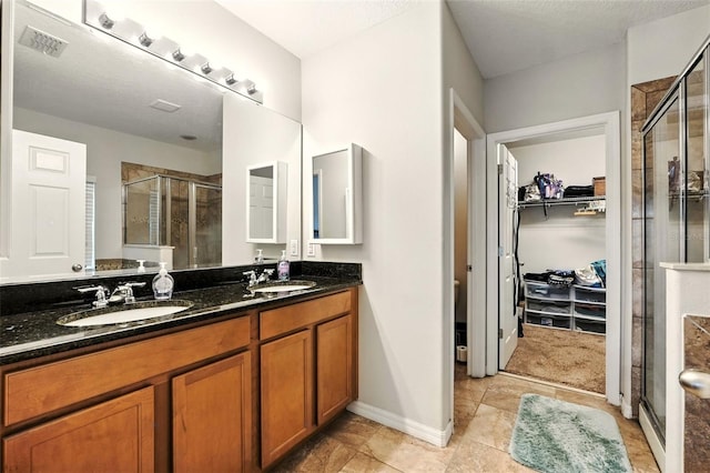 301 Sierra Way, Davenport, FL 33837 - full bathroom with a stall shower, a walk in closet, double vanity, and tile patterned flooring