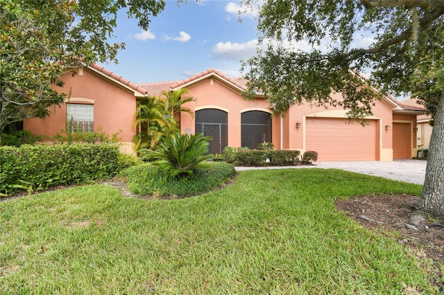 521 Milano Rd, Kissimmee, FL 34759 - mediterranean / spanish-style home with a garage, a front lawn, stucco siding, driveway, and a tiled roof