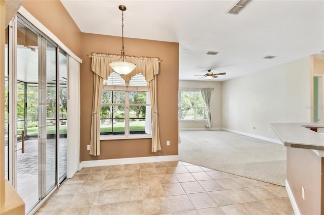 521 Milano Rd, Kissimmee, FL 34759 - unfurnished dining area with light carpet, a ceiling fan, and light tile patterned flooring