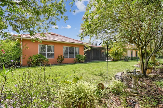 521 Milano Rd, Kissimmee, FL 34759 - back of property featuring stucco siding, a sunroom, and a tiled roof
