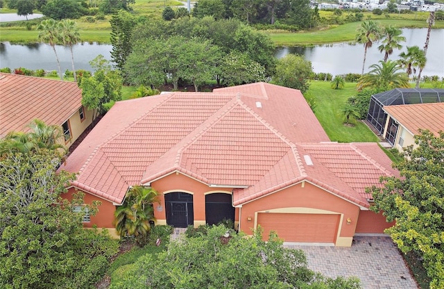 521 Milano Rd, Kissimmee, FL 34759 - view of front facade featuring a garage, a tiled roof, a water view, stucco siding, and driveway