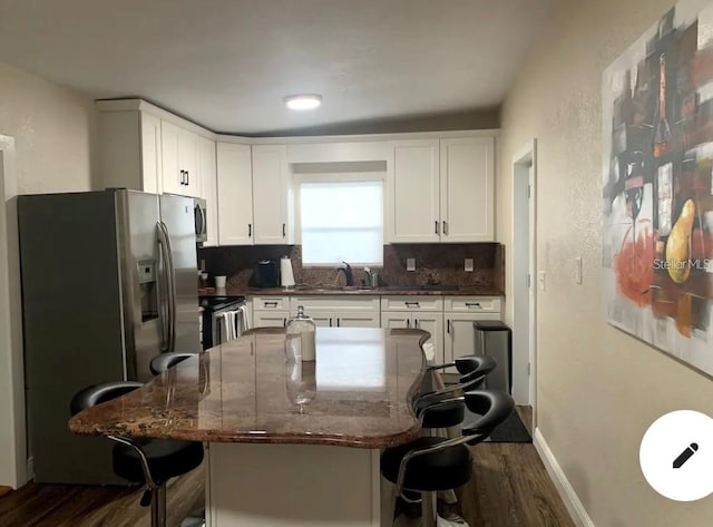 2940 Lake Margaret Dr, Orlando, FL 32806 - kitchen with stainless steel appliances, dark wood-type flooring, a breakfast bar, and white cabinetry