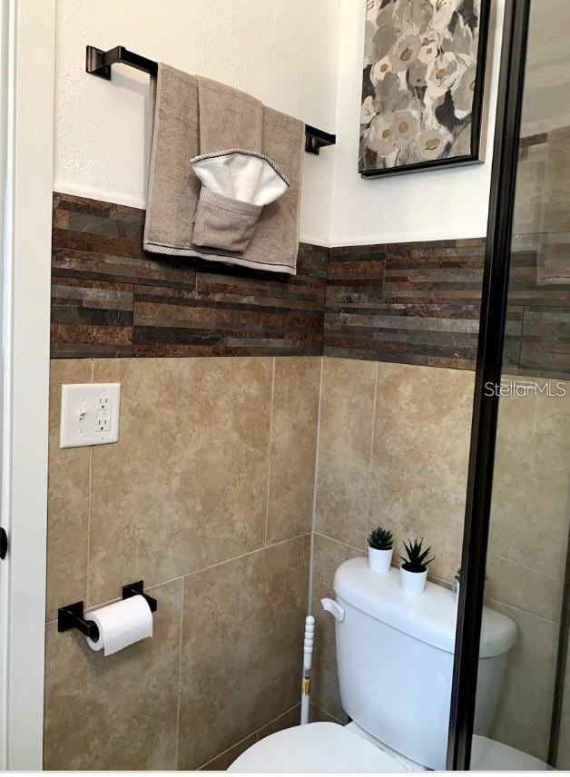 2940 Lake Margaret Dr, Orlando, FL 32806 - bathroom featuring tile walls and a wainscoted wall