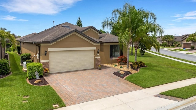802 Soria Ln, Davenport, FL 33837 - single story home featuring stucco siding, stone siding, decorative driveway, a garage, and a front lawn