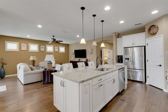 802 Soria Ln, Davenport, FL 33837 - kitchen with stainless steel appliances, ceiling fan, an island with sink, wood finished floors, and open floor plan